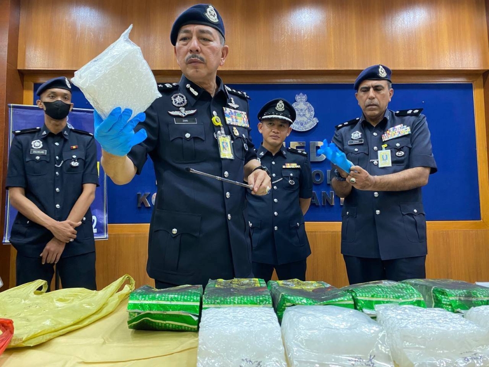 Muhamad Zaki (di hadapan) menunjukkan ketulan syabu yang berjaya dirampas dalam serbuan di tepi Jalan Wakaf Che Yeh, Mukim Padang Enggang, Kota Bharu pada Selasa.