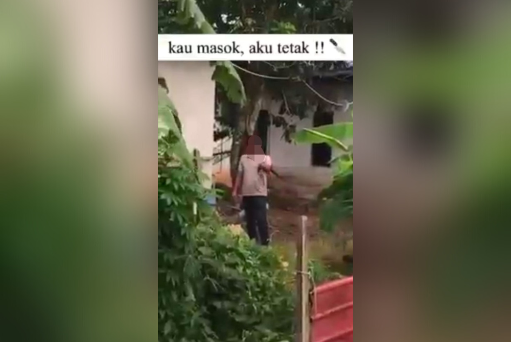 Tangkap layar video tular yang memaparkan suspek melakukan ugutan sambil memegang sebilah parang dalam kejadian di Pantai Remis, Manjung. - Foto ihsan pembaca