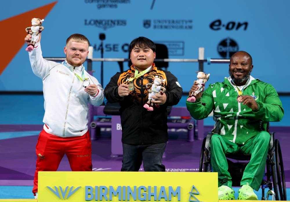 Atlet powerlifting negara Bonnie Bunyau Gustin bergambar bersama pemenang pingat Perak dari England, Mark Swan (kiri) dan pemenang pingat Gangsa dari Nigeria, Innocent Nnamdi. -Foto Bernama