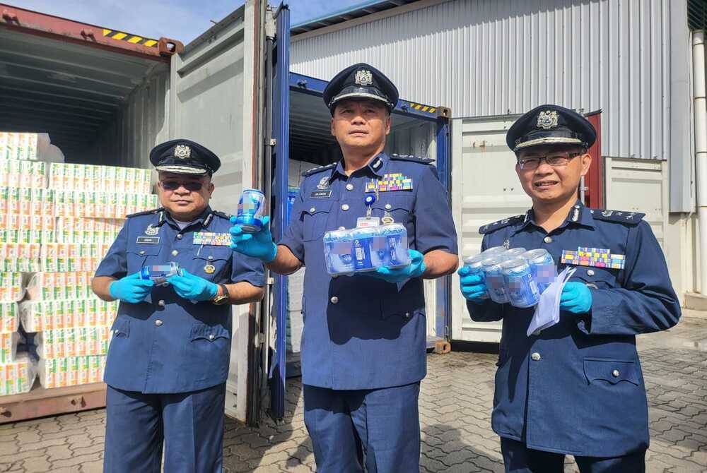 Julaiman (tengah) menunjukkan minuman keras yang diseludup masuk menggunakan kontena di Pelabuhan Sepanggar, Kota Kinabalu.