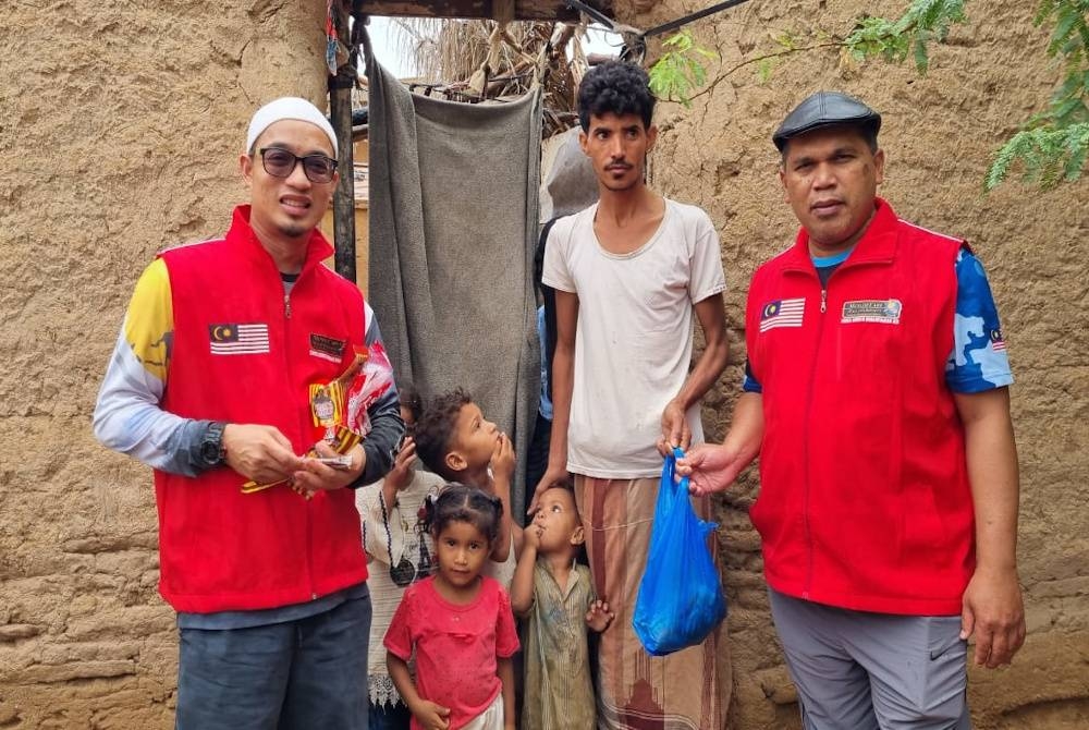 Zulkifli (kanan) menyerahkan daging sembelihan di sekitar pusat penempatan pelarian Madoodah, Seiyun.