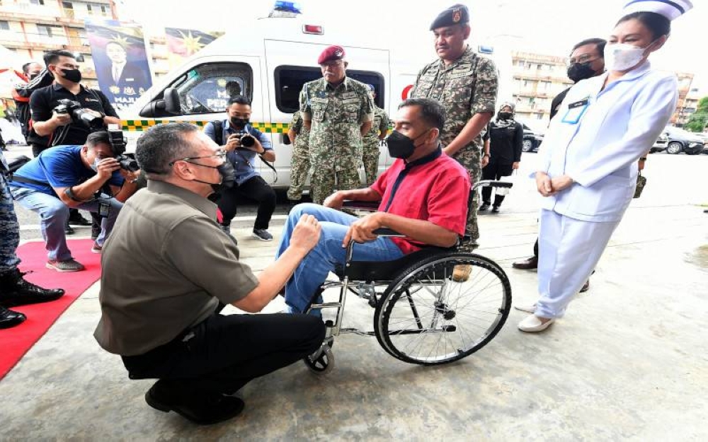 Menteri Kanan Pertahanan Datuk Seri Hishammuddin Tun Hussein menyantuni seorang veteran tentera ketika hadir pada perasmian Poliklinik Kesihatan Angkatan Tentera Malaysia (ATM) Kem Penrissen, pada Jumaat. - Foto Bernama
