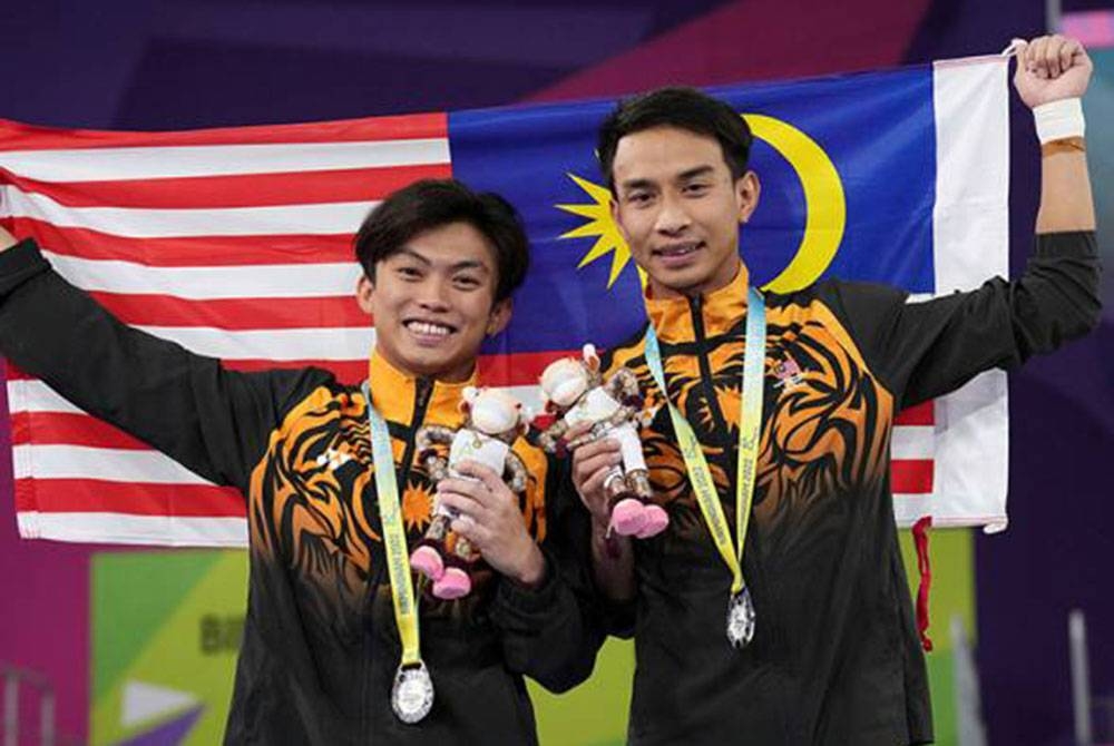 Muhammad Syafiq (kanan) berjaya merangkul pingat perak bersama gandingannya, Gabriel Gilbert Daim pada final acara lelaki 3m papan anjal seirama. - Foto AP