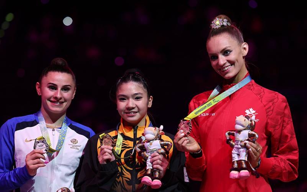 Joe Ee (tengah) bergambar bersama pemenang pingat perak dari Scotland, Christie Louise(kiri) dan Pingat gangsa dari Canada, Carmel Kallema pada penyampaian pingat acara &#039;Ribbon&#039; gimnastik berirama sempena Sukan Komanwel 2022 Birmingham di Arena Birmingham pada Sabtu. - Foto Bernama