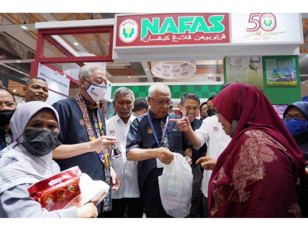 Perdana Menteri, Datuk Seri Ismail Sabri Yaakob (tengah) dan Pengerusi Ahli Jemaah Pengarah Nafas, Datuk Zamri Yaakob, menjual ayam pada harga RM5 sewaktu sesi happy hour di Pavillion Nafas di Dewan A, Taman Ekspo Pertanian Malaysia Serdang (MAEPS) pada Sabtu.