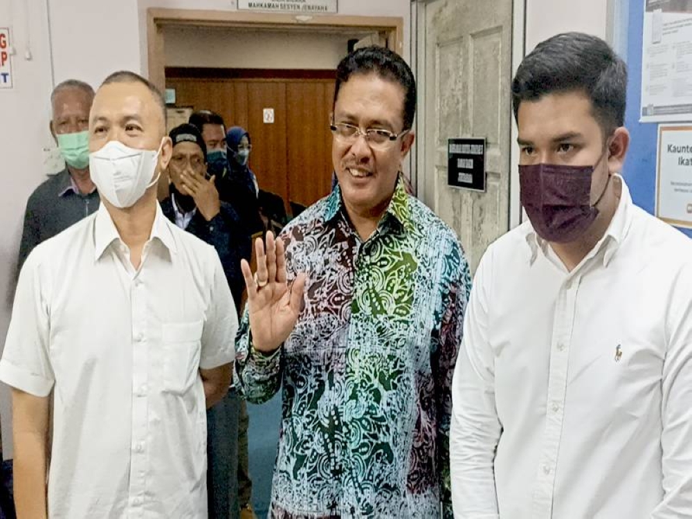 Abd Latif ( tengah) melambai tangan kepada petugas media selepas dilepas dan dibebaskan atas pertuduhan rasuah dan penggubahan wang haram di Mahkamah Sesyen Johor Bahru pada Ahad.