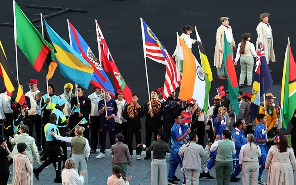 Pelari pecut negara, Russel Alexander Nasir Taib bersama penerjun negara, Gilbert gabriel daim membawa Jalur Gemilang bagi kontinjen Malaysia pada Majlis Penutupan Sukan Komanwel Birmingham 2022 di Stadium Alexander pada Isnin. - Foto Bernama