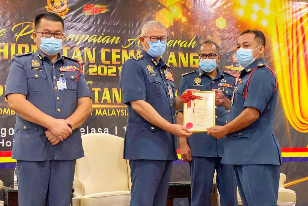 Mohammad Hamdan (dua dari kiri) menyampaikan anugerah perkhidmatan cemerlang kepada pegawai JBPM Kelantan di Kota Bharu, pada Selasa.