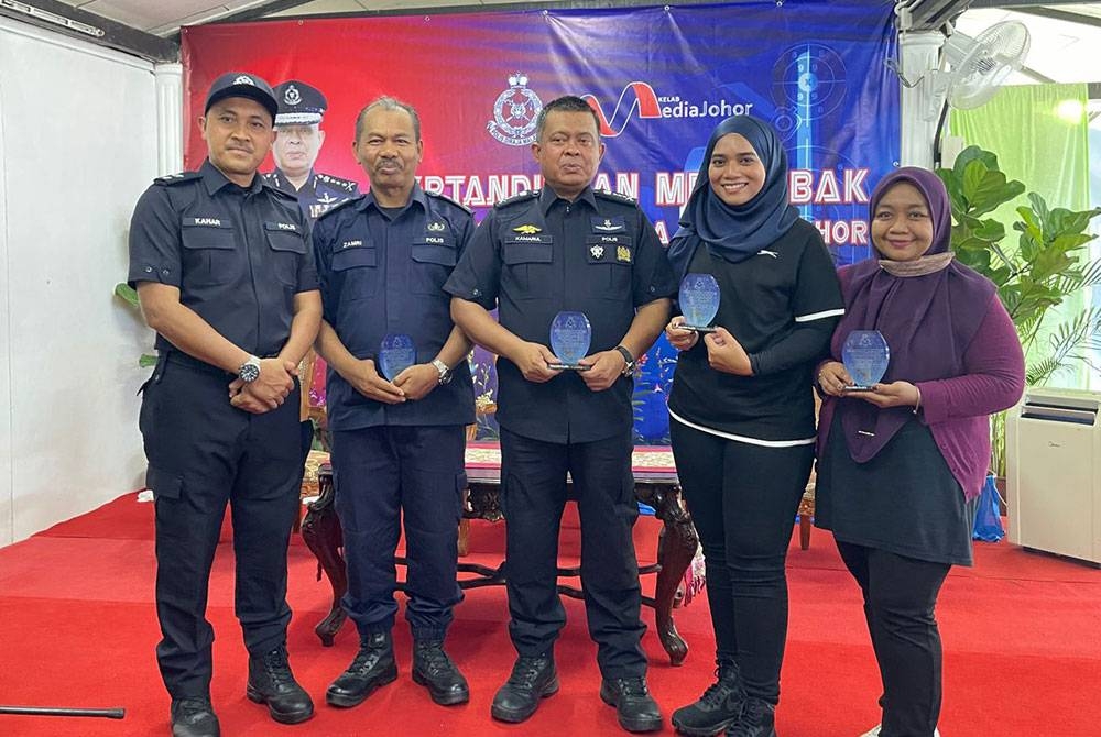 Kamarul Zaman (tengah) bersama-sama petugas media selepas Pertandingan Menembak Polis Johor Bersama Media Johor Sempena Hari Polis di Lapang sasar, Ladang REM, Kota Tinggi, pada Selasa.