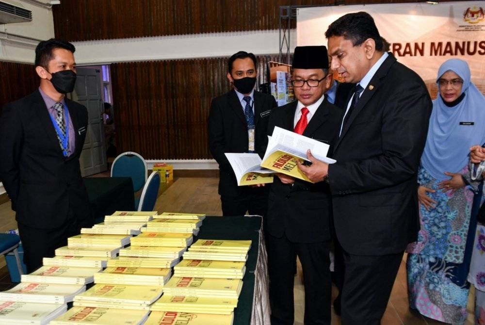 Santhara (dua dari kanan) melihat bahan bacaan berkaitan manuskrip ketika melawat ruang pameran selepas merasmikan Persidangan dan Pameran Antarabangsa Manuskrip Melayu 2022 di UPSI pada Selasa. - Foto Bernama 