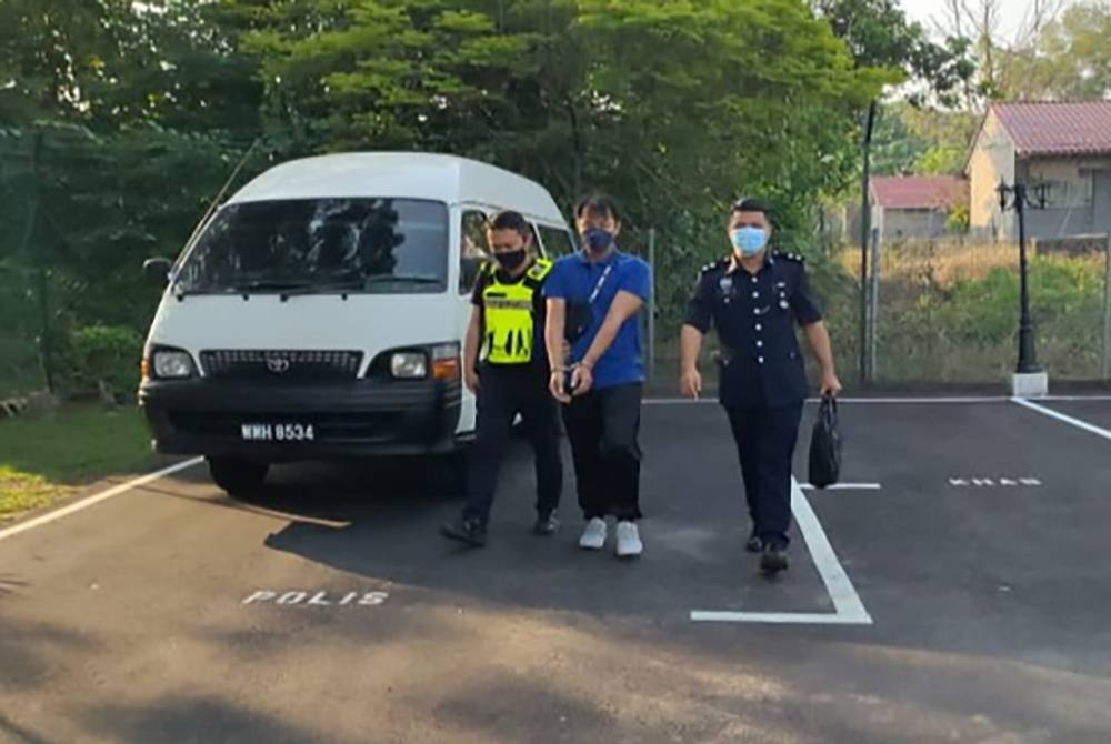 Tertuduh diiringi anggota polis sebaik tiba di pekarangan mahkamah pada Rabu.