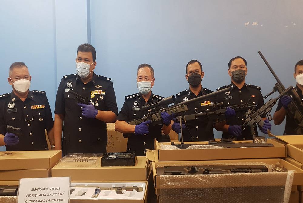 Eng Lai (tengah) menunjukkan antara pistol mainan yang dirampas.