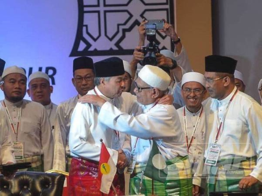 Ahmad Zahid dan Presiden Pas, Datuk Seri Abdul Hadi Awang berpelukan selepas menandatangani Piagam Muafakat Nasional pada Himpunan Penyatuan Ummah di Pusat Dagangan Dunia Putra (PWTC) pada 14 September 2019. 