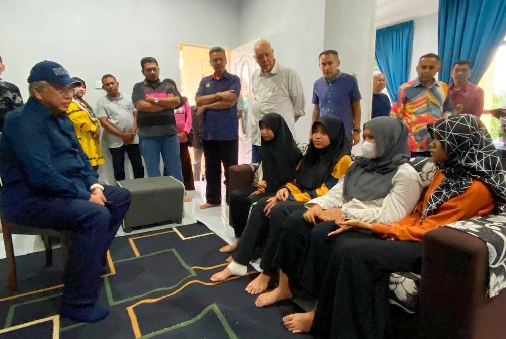 Annuar (kiri) bertanyakan khabar pada empat pelajar SMK Melor yang menjadi mangsa tangki air pecah semasa melawat mereka di Kampung Tasik Sri Kulim pada Khamis.