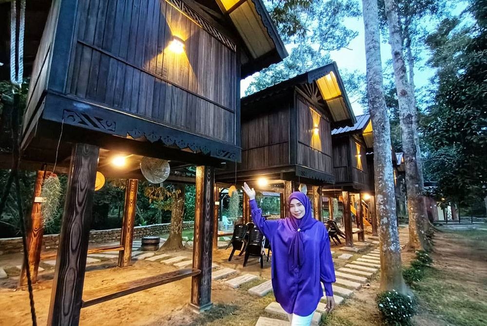 Wan Fatimah bergambar di hadapan chalet yang disediakan untuk pengunjung yang ingin menginap.