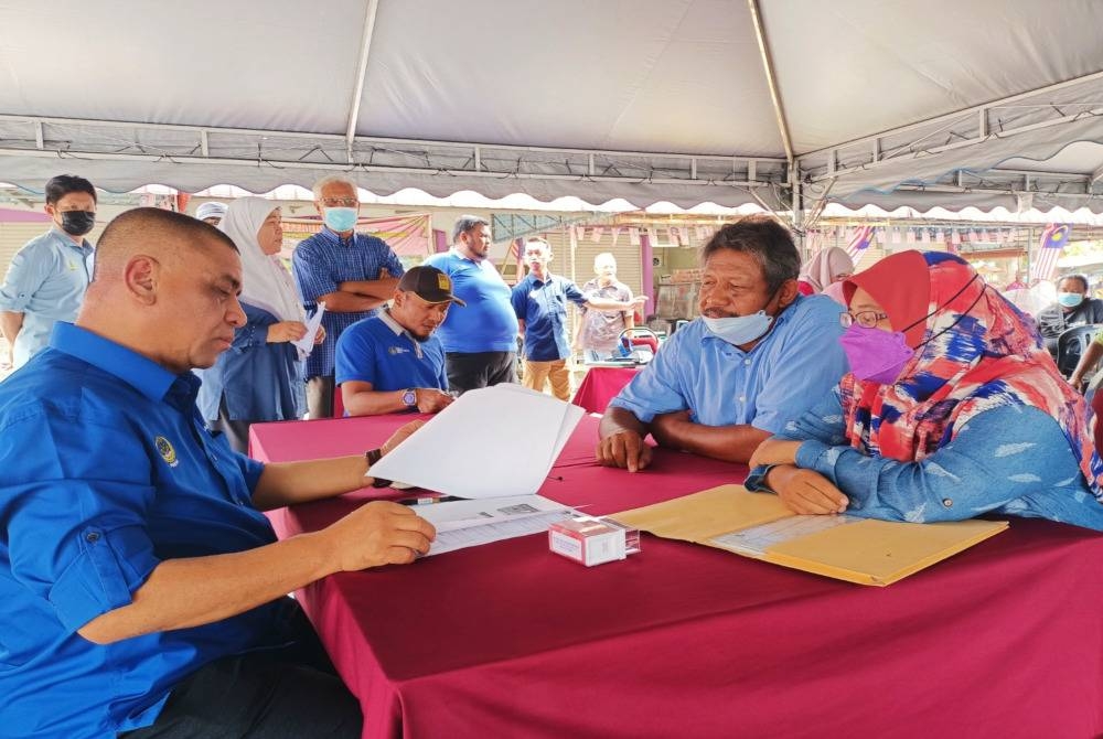 Menteri Besar Perak, Datuk Seri Saarani Mohamad menyemak aduan dikemukakan penduduk sempena program Hari Bertemu Rakyat DUN Kota Tampan di Dataran Tasik Raban, Lenggong pada Jumaat.