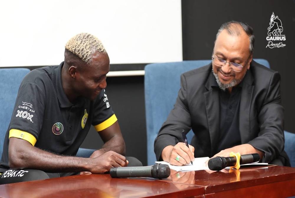 Afolabi (kiri) menyambung kontrak selama dua tahun bersama Perak FC sambil disaksikan Bobie Farid dalam satu majlis pada Sabtu. - FOTO: PERAK FC