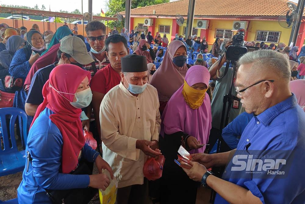 Noh (kanan) menyampaikan sumbangan zakat Bank Rakyat pada Majlis Penyerahan Sumbangan Bank Rakyat Parlimen Tanjong Karang di SK Berjaya di sini pada Sabtu.