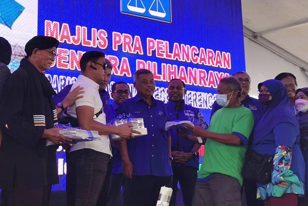 Ahmad (tengah) menerima borang keahlian baharu UMNO pada majlis perasmian pelancaran jentera BN Terengganu, di Pantai Penunjuk, Kijal, di Kemaman, pada Sabtu.