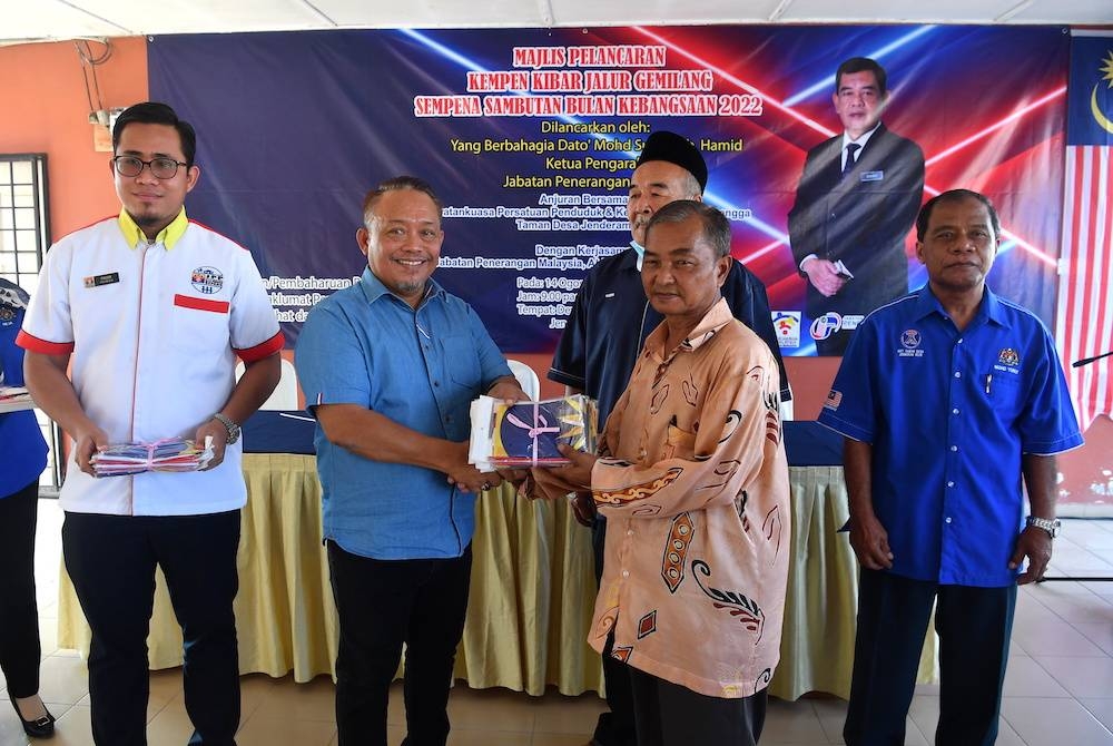 Suwadi (dua dari kiri) menyerahkan Jalur Gemilang kepada Pengerusi Persatuan Penduduk Taman Desa Jenderam Hilir, Zainal Abidin Mohd Daim (dua dari kanan) ketika Program Kempen Kibar Jalur Gemilang sempena Sambutan Bulan Kebangsaan 2022 di Dewan Serbaguna Taman Desa Jenderam Hilir pada Ahad. - Foto Bernama