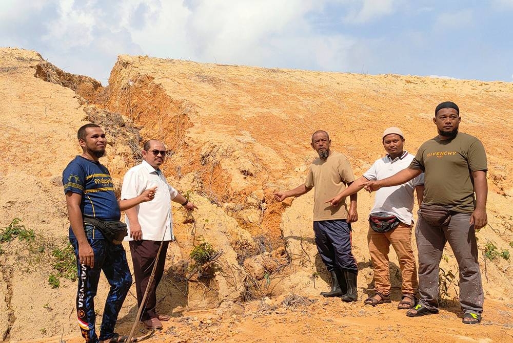 Shamsul Iskandar (dua dari kiri) bersama Ahmad Haikal (kiri sekali), Misdar (tengah) dan Danial (kanan sekali) meninjau keadaan tanah runtuh yang sering berlaku setiap kali hujan.