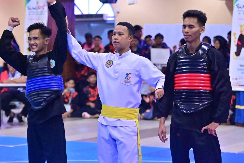 Mohamad Firdaus (kiri) dinobatkan sebagai juara bagi acara silat tanding kelas B