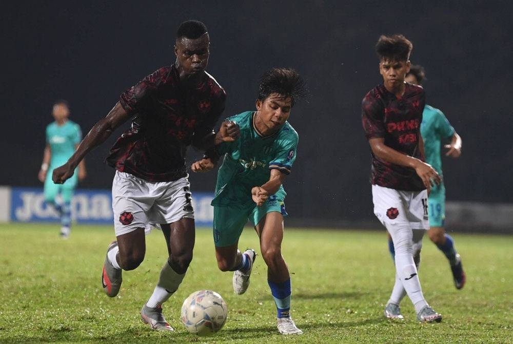 Pemain pasukan Selangor FC 2, Richmond Tetteh Ankrah (kiri) cuba mengawal bola sambil diasak pemain pasukan Terengganu FC 2, Muhammad Nur Azfar Fikri Azhar pada perlawanan Liga Premier Malaysia 2022 di Stadium Universiti Teknologi Mara (UiTM), pada Isnin.