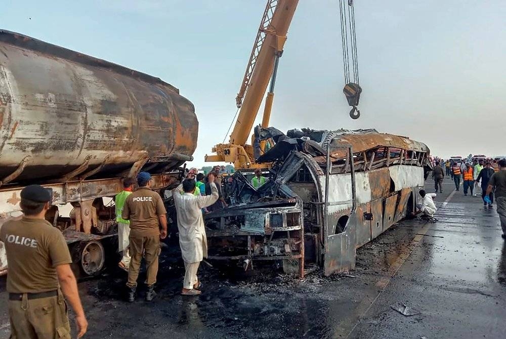 Sebuah bas penumpang terbakar selepas bertembung dengan lori tangki minyak berhampiran daerah Jalalpur Pirwala di wilayah Punjab timur Pakistan. - Foto AP