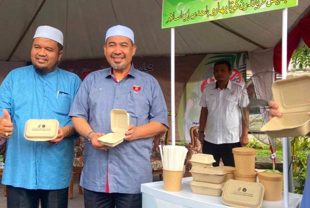 Izani (dua dari kiri) menunjukkan bekas makanan yang mesra alam boleh digunakan oleh peniaga.