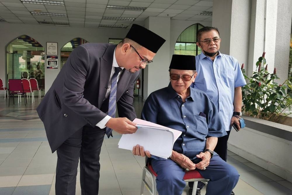 Tengku Ibrahim (duduk) bersama peguamnya, Musa (kiri) di pekarangan Mahkamah Rayuan Syariah Negeri di Kuala Terengganu pada Rabu.