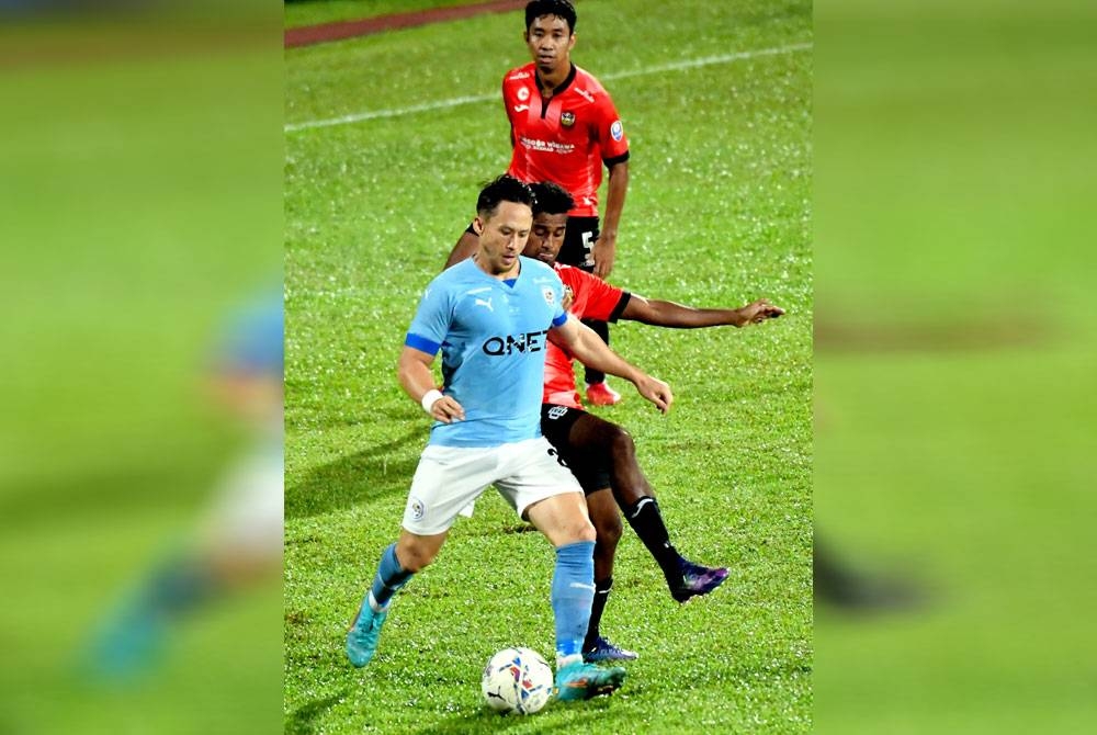 Pemain PJ City, Darren Lok (kiri) diasak pemain Sarawak United pada saingan Liga Super di Stadium Negeri pada Rabu. - Foto Bernama