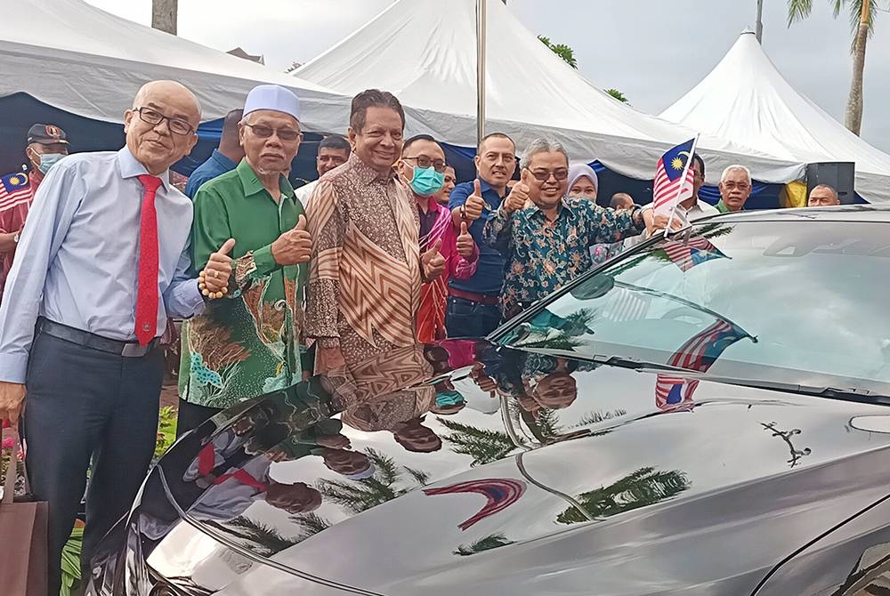 Rumaizi (kanan) melakukan pemasangan bendera pada kenderaan sempena program Kibar Jalur Gemilang Peringkat MBI di Persiaran Bandaraya pada Khamis.