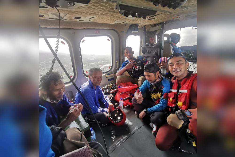 Mohd Yazid (belakang kiri) bersama pemancing lain diselamatkan pasukan Stesen Udara Maritim Subang menggunakan pesawat pada Khamis.