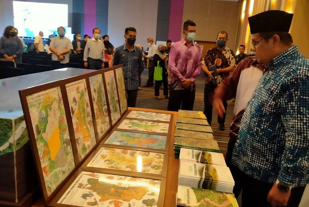 Mohd Akmal (kanan) melihat ruang pameran sempena Program Central Forest Spine Showcase Bersama Pemegang-pemegang Taruh Peringkat Negeri Perak di Pusat Konvensyen Casuarina @ Meru, di sini pada Khamis.