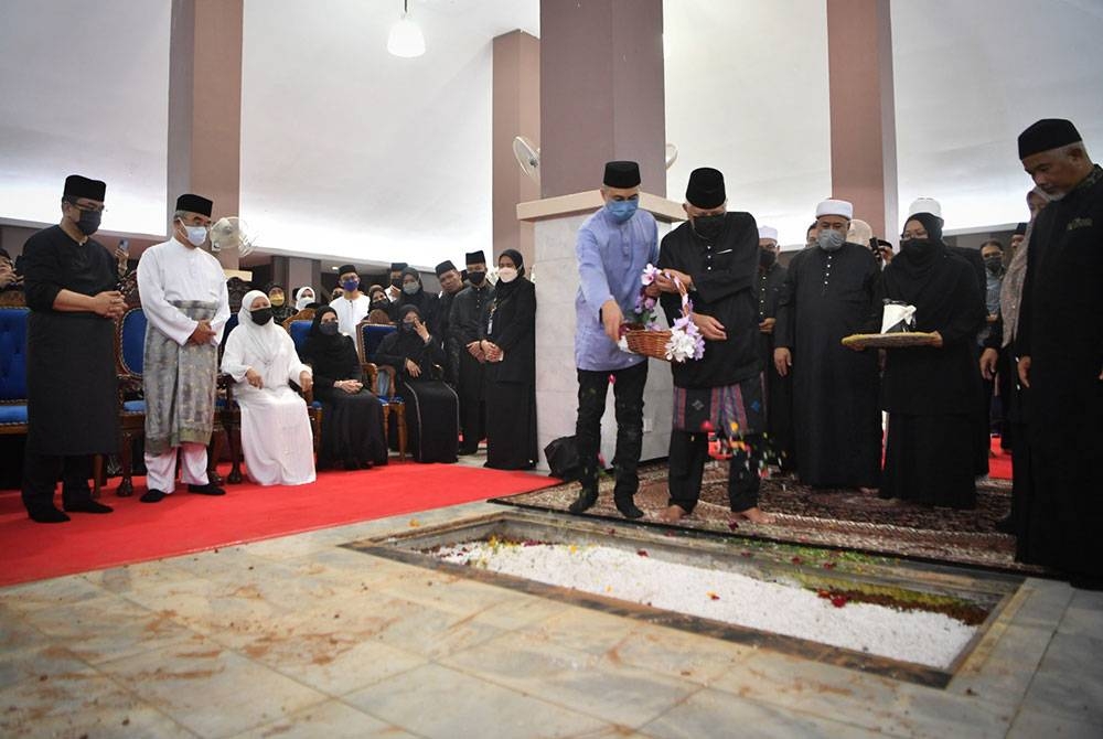 Mohd Khalil bersama anak beliau, Datuk Mahmud Mohd Khalil menabur bunga mawar di pusara Isterinya Toh Puan Zurina Kassim selepas selamat disemadikan di Makam Pahlawan Masjid Al-Azim dekat Bukit Palah, hari ini. - Foto Bernama