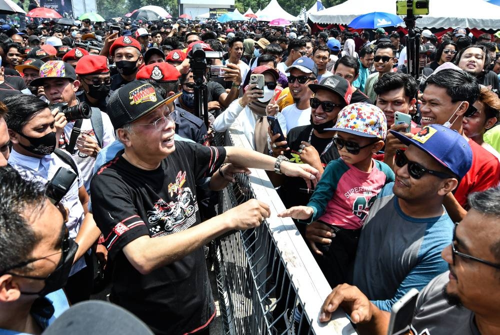 Ismail Sabri(dua, kiri) beramah mesra dengan orang ramai pada Perasmian Program RXZ ‘Members’ 4.0 2022 di Litar Permotoran Terengganu, Kompleks Sukan Negeri Gong Badak pada 13 Ogos. - Foto Bernama 