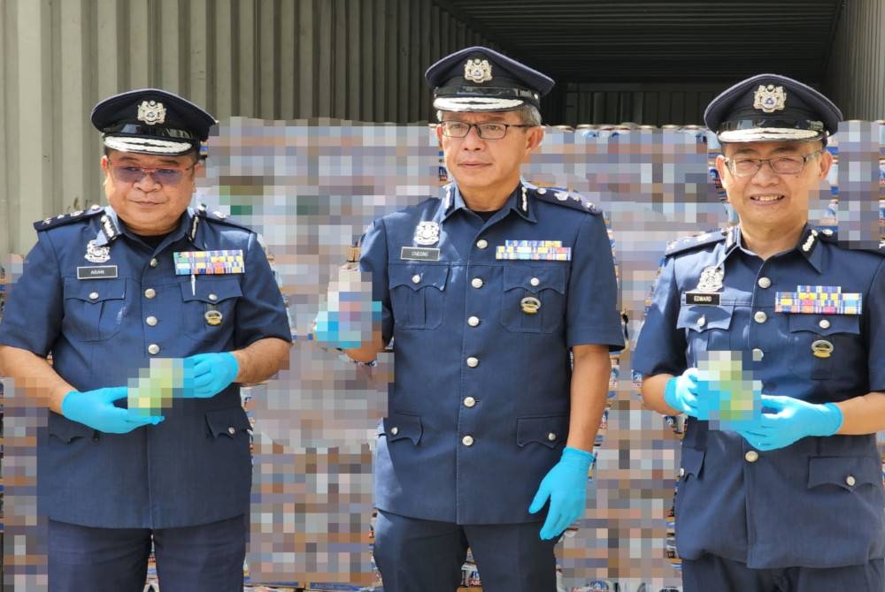 Yu Min (tengah) menunjukkan minuman keras yang cuba diseludup masuk menerusi kontena di Pelabuhan Sepanggar, Kota Kinabalu.