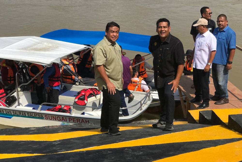 Yahanis (kiri) bersama Khairul Shahril (kanan) melihat landas bot yang siap dibina di Lambor Kanan, Bota pada Jumaat.