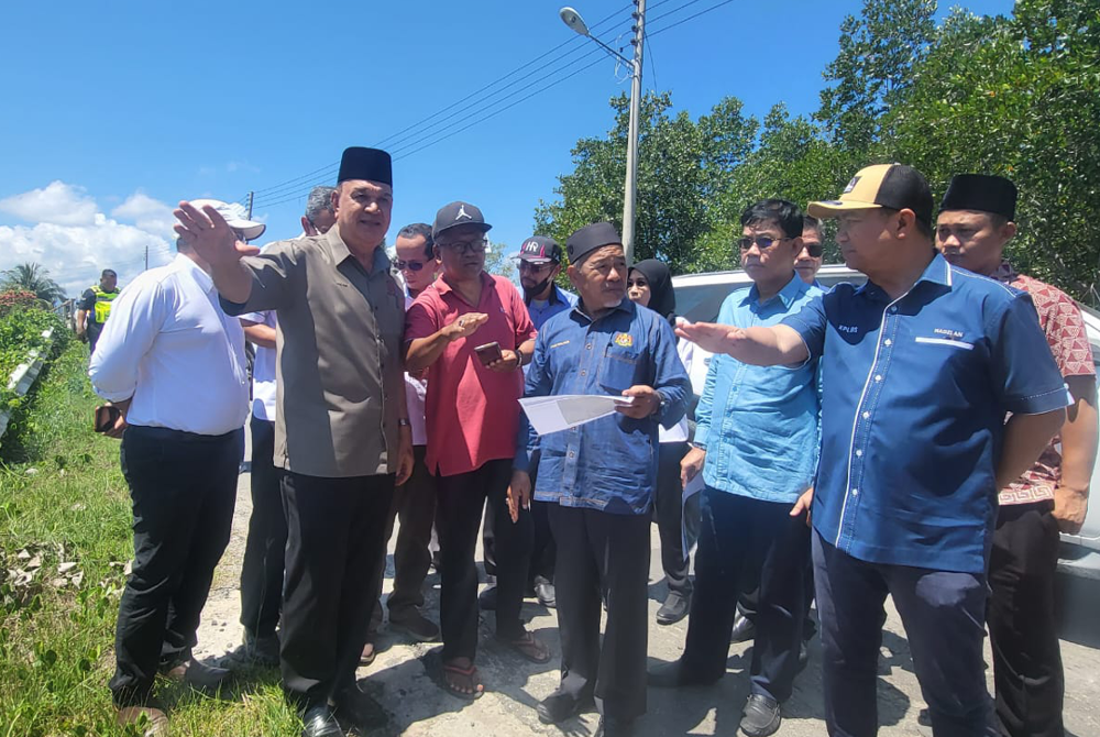 Tuan Ibrahim (tiga dari kanan) mendengar taklimat berkaitan kawasan bakal dilaksana projek tangani banjir di Kampung Pengalat.