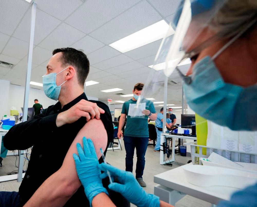 Seorang lelaki diberi vaksin di klinik vaksinasi cacar monyet yang dikendalikan pihak berkuasa kesihatan awam di Montreal, Quebec, Kanada. - Foto fail Reuters