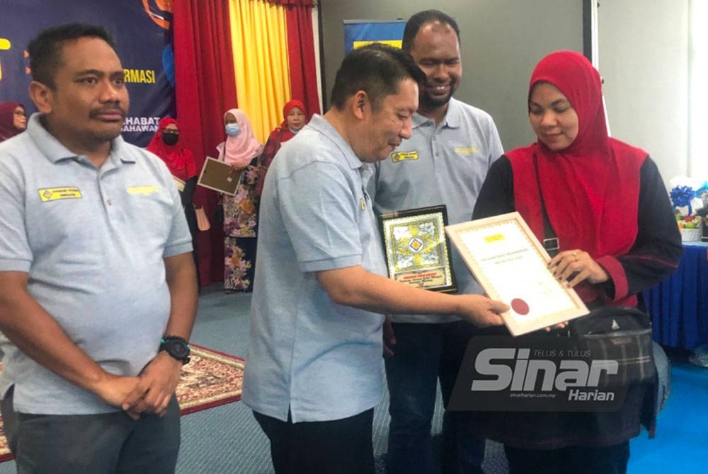 Ahmad Jazlan (dua dari kanan) menyampaikan sijil penghargaan Anugerah Khas Sahabat kepada Normazura (kanan) di Pusat Transformasi Ilmu pada Sabtu.