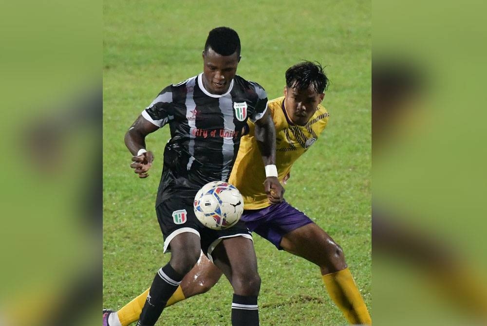 Penyerang Kuching City FC, Abu Kamara berusaha mengawal bola ketika diasak oleh pemain UiTM FC pada saingan Liga Premier di Stadium Negeri di sini hari ini. - Foto Bernama