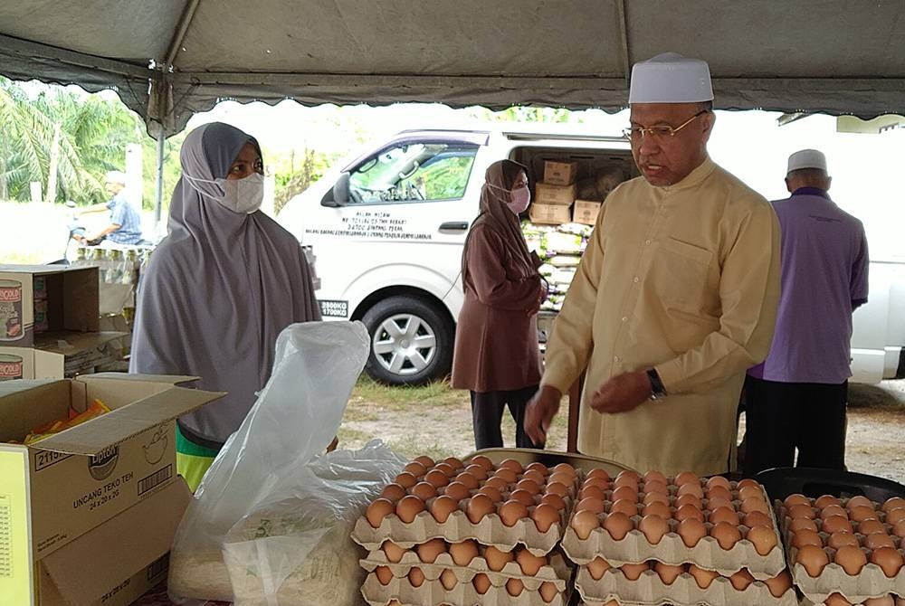 Idris melihat barangan yang dijual sempena Program Jualan Amal di Markaz Pas Sungai Tinggi, Trong pada Ahad