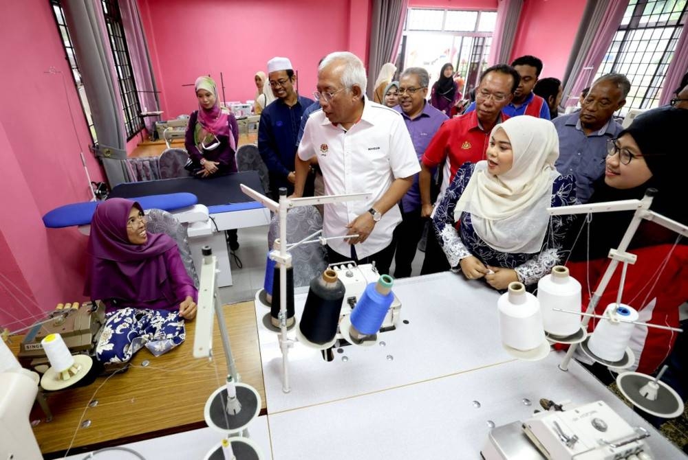 Mahdzir (tengah) melawat Pusat Daya Maju Kemas di Bengkel Jahitan Kemas Daerah Padang Terap, Kuala Nerang pada Ahad.