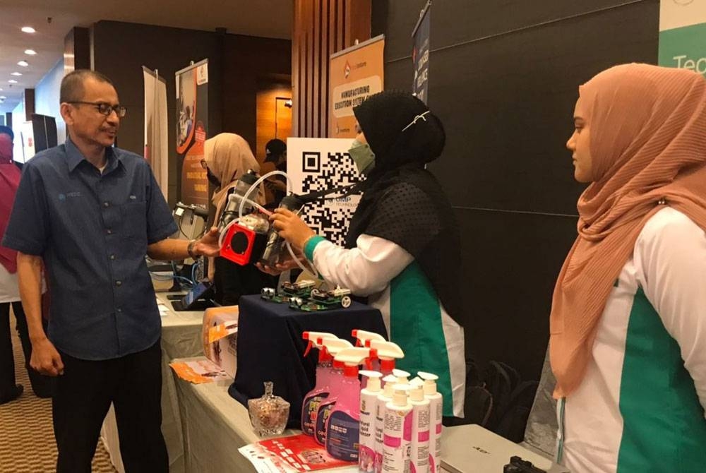 Mohammad Hazani melihat inovasi produk yang dihasilkan di gerai pameran selepas merasmikan program Road2Growth MTDC zon Pantai Timur di sebuah hotel, pada Isnin.