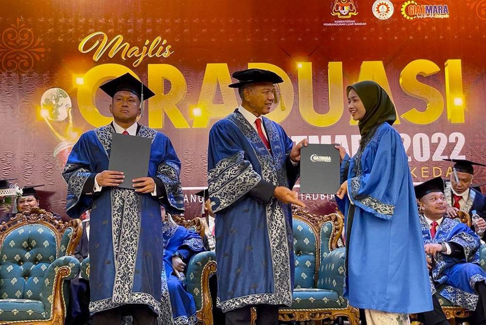 Jabar Azman (tengah) menyerahkan sijil kepada salah seorang penuntut GiatMara pada Majlis Graduasi GiatMara 2022 Negeri Kedah di Dewan Tunku Anum, di sini, pada Isnin.