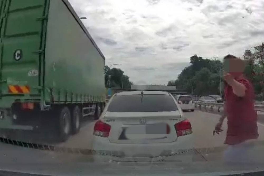 Tangkap layar kejadian seorang lelaki membaling objek ke arah kereta dinaiki pasangan suami isteri dalam kejadian di Lebuh Raya Lembah Klang Baru (NKVE), pada Ahad