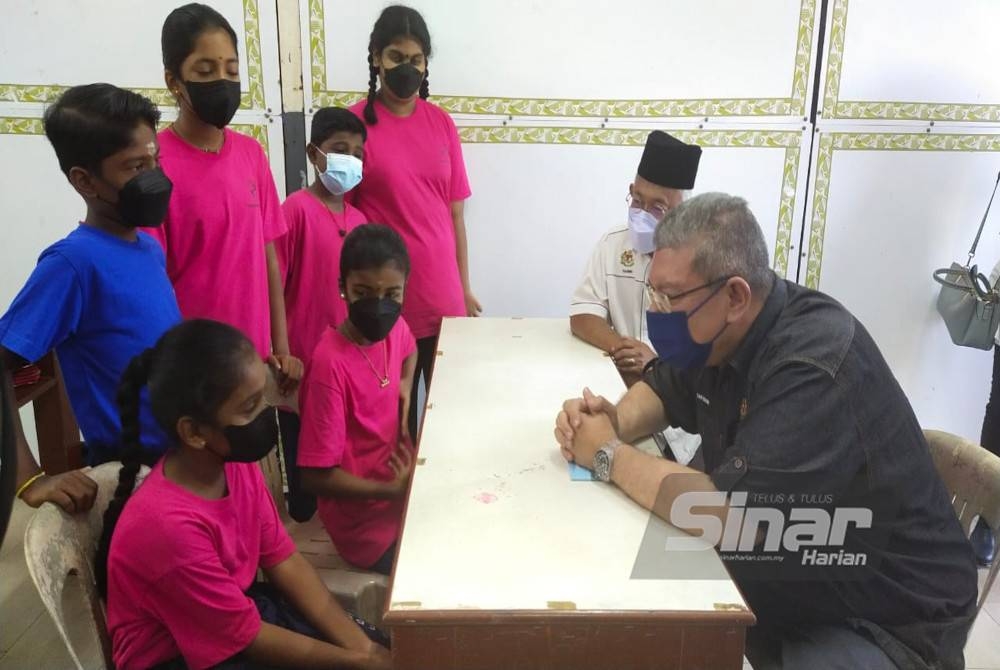 Saifuddin (kanan) beramah mesra bersama sebahagian murid SJKT Ladang Jeram pada lawatannya ke sekolah itu di sini pada Rabu.