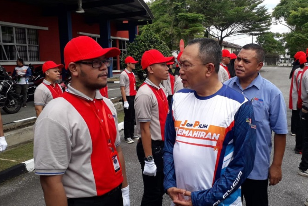 Awang (kanan) ketika melakukan pemeriksaan perbarisan dalam program Jelajah Outreach TVET di Pusat Giat Mara Pasir Gudang, Johor Bahru pada Rabu.