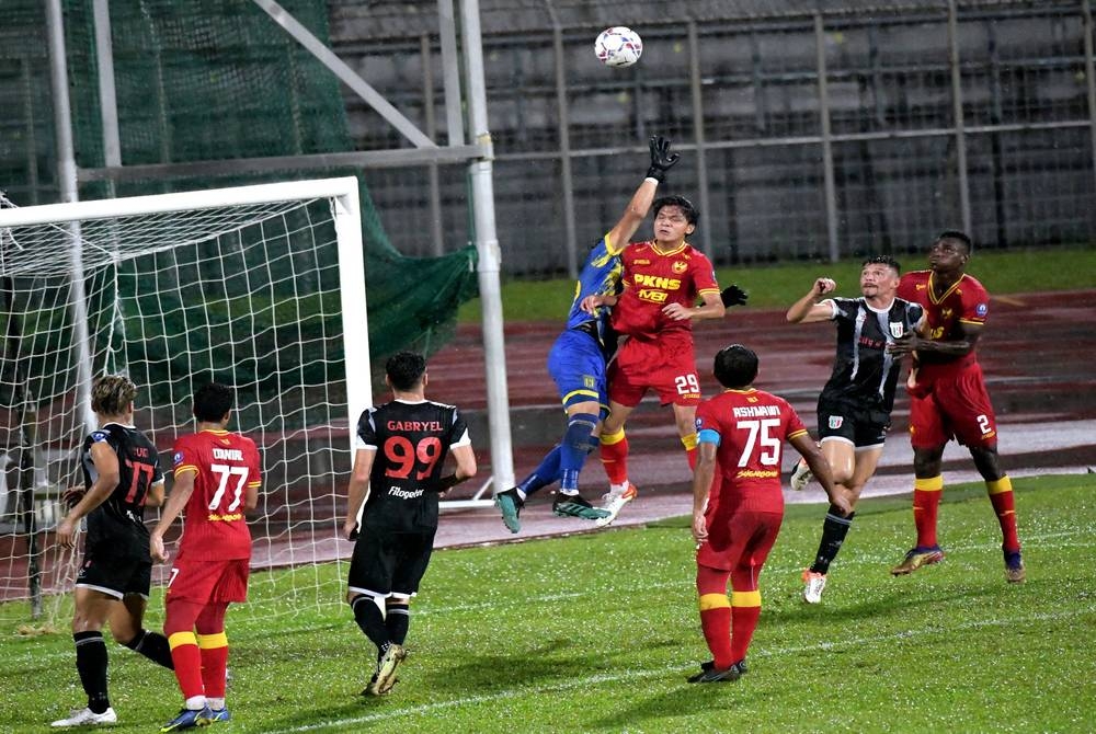 Penyerang Selangor 2, Faiz Amer menggasak penjaga gol Kuching City, Shaiful Wazizi Mohammad pada saingan Liga Premier di Stadium Negeri pada Rabu. -Foto Bernama